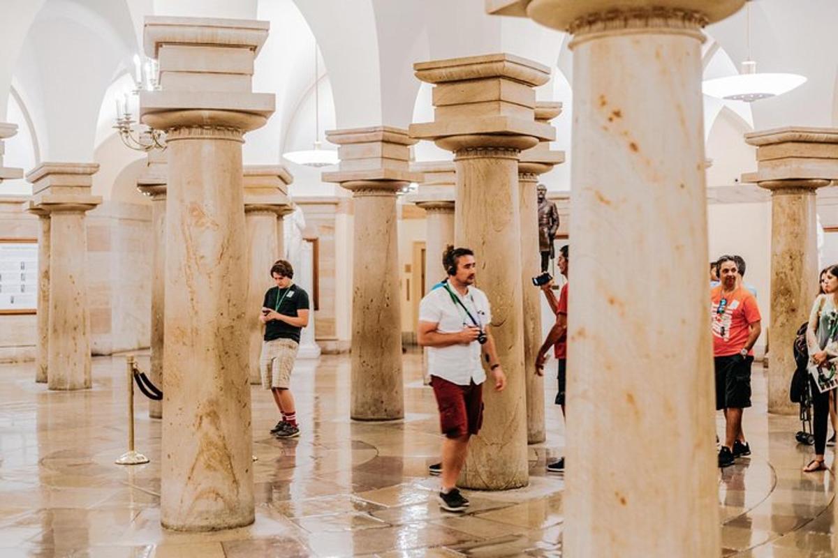 a group of people standing in a room with columns