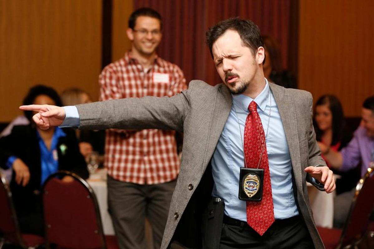 a man in a suit and tie with his arm outstretched