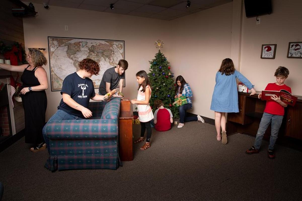a group of people standing around a christmas tree