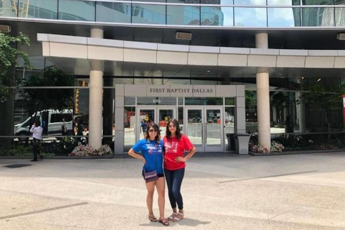two women standing in front of a building
