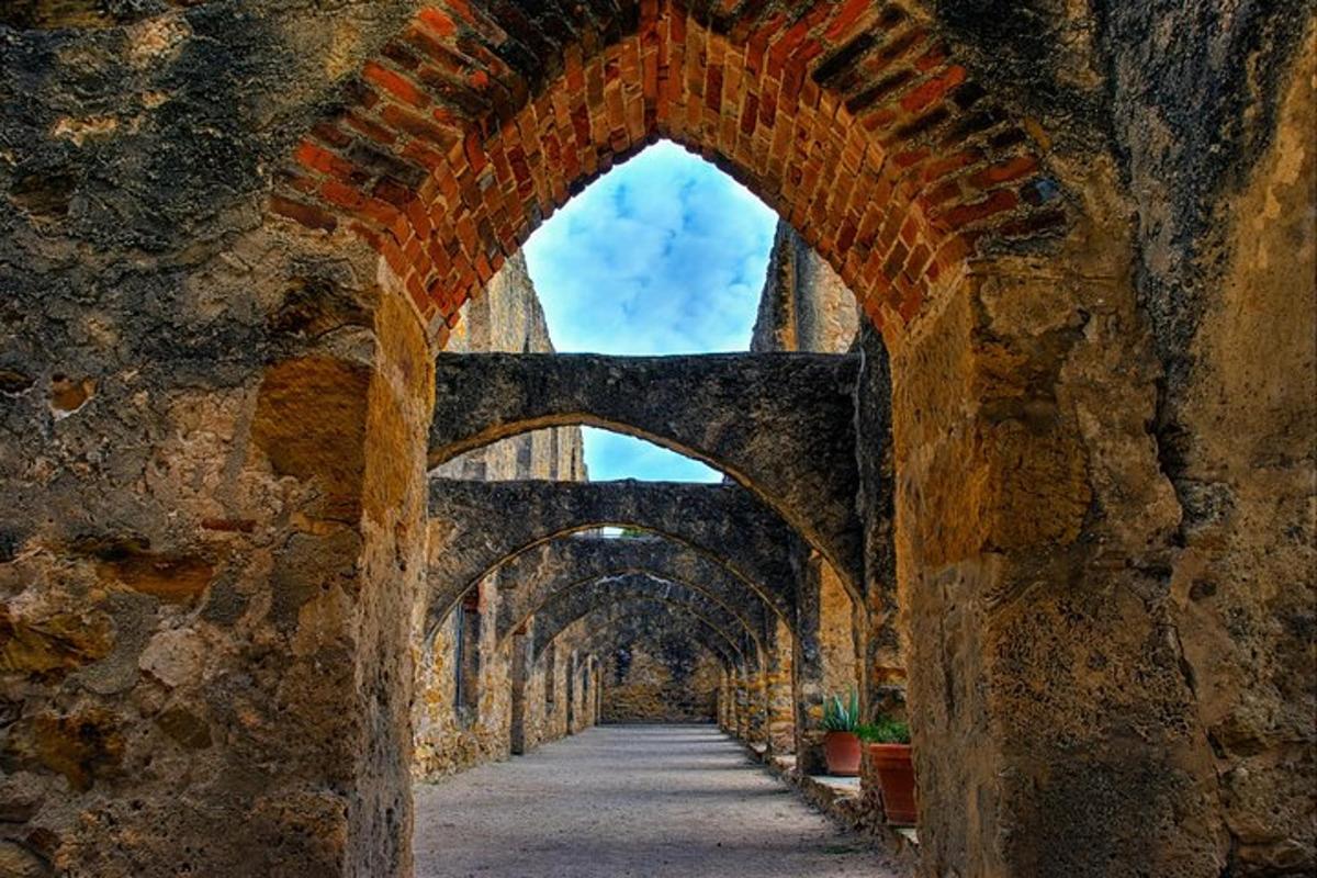 an archway in a stone wall with a pathway