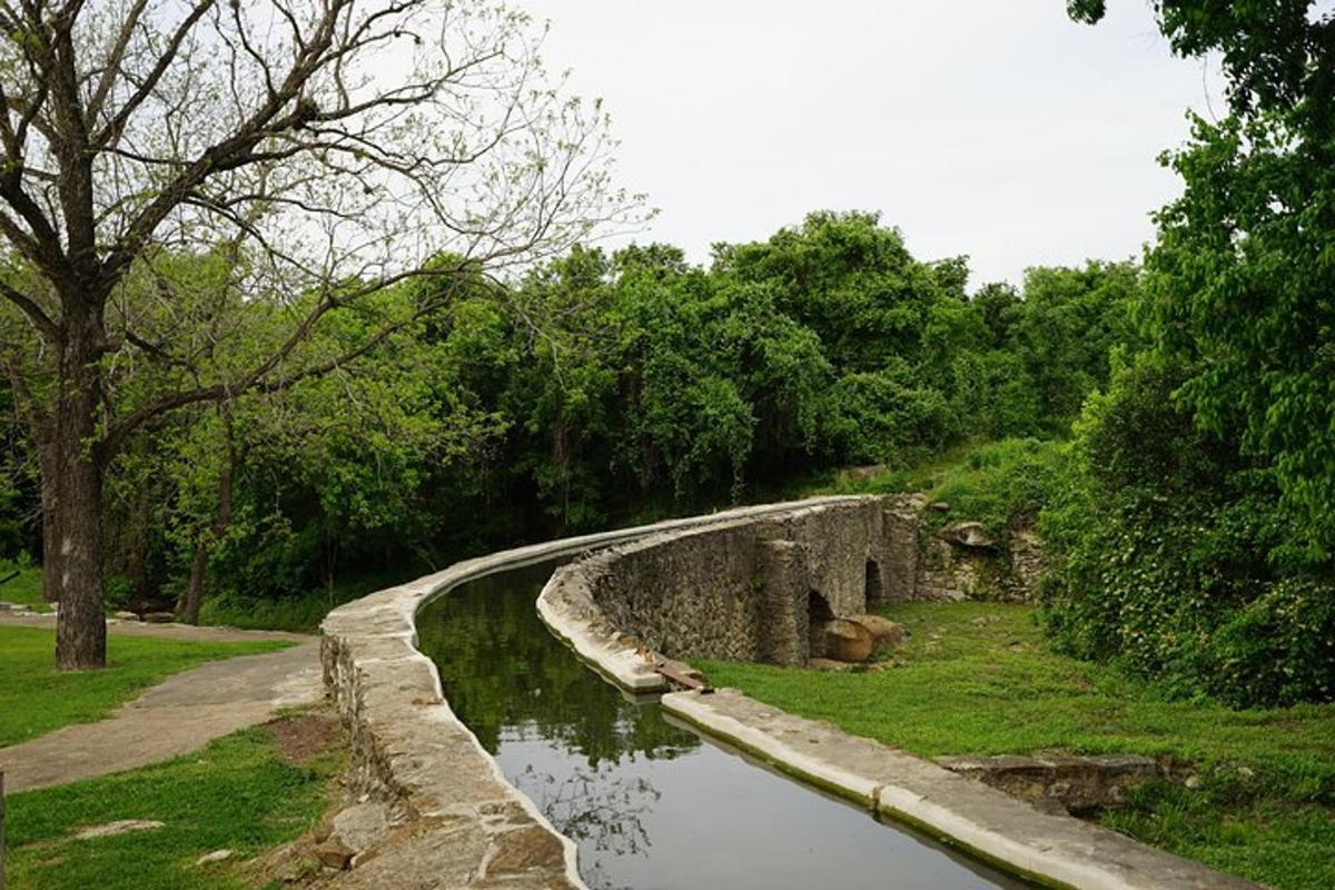 a stone wall next to a body of water