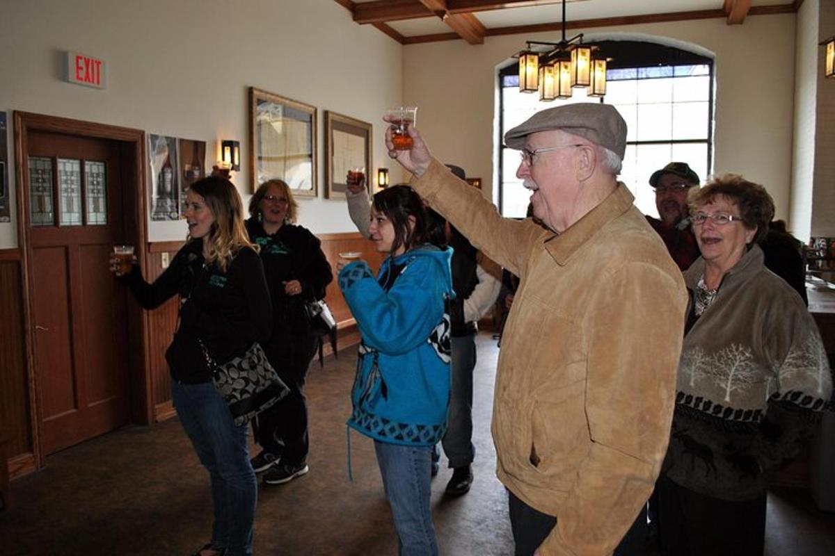 a group of people standing in a room with a man holding a glass