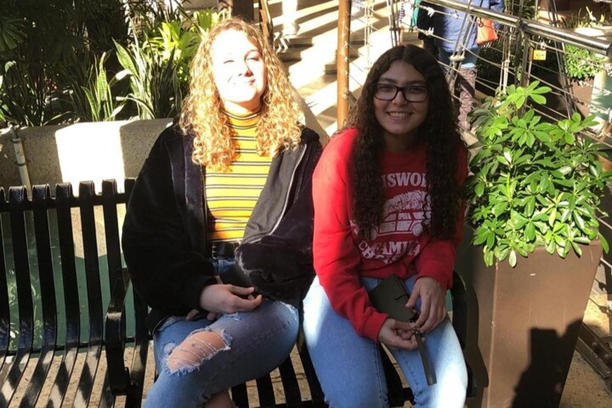 due ragazze sono sedute su una panchina