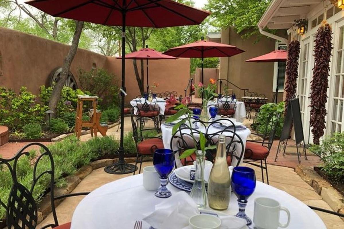 a group of tables with blue glasses and umbrellas