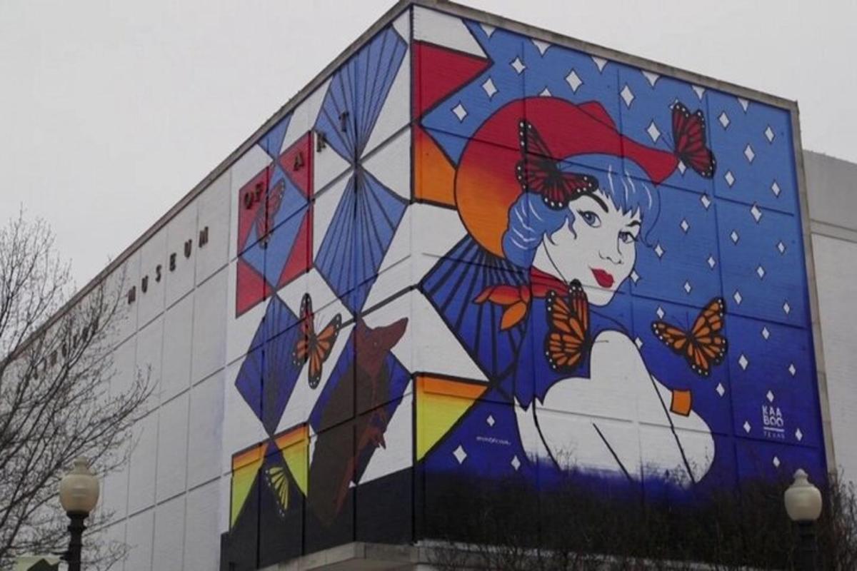 o pictură murală pe lateralul unei clădiri cu fluturi
