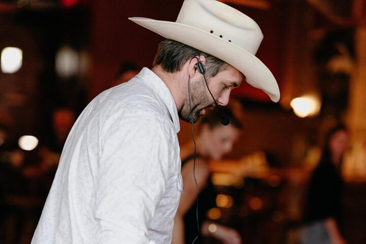 a man wearing a cowboy hat talking on the phone