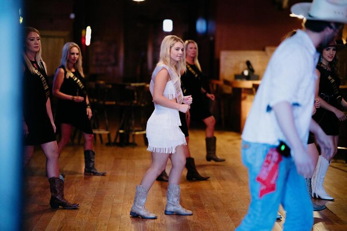 a woman in a white dress dancing on a dance floor