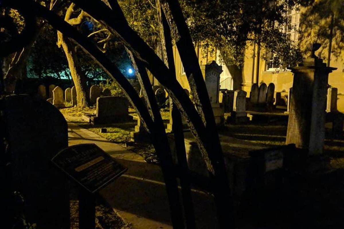 a cemetery at night with a bench in the foreground
