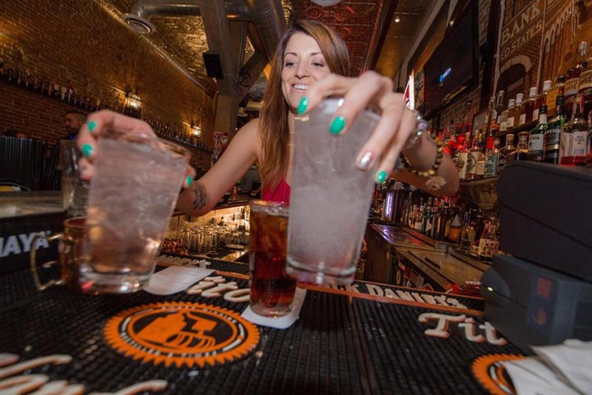 a woman standing at a bar making a drink