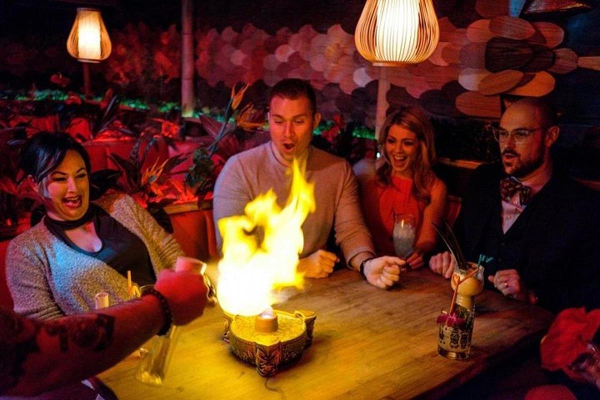 a group of people sitting around a table with a fire
