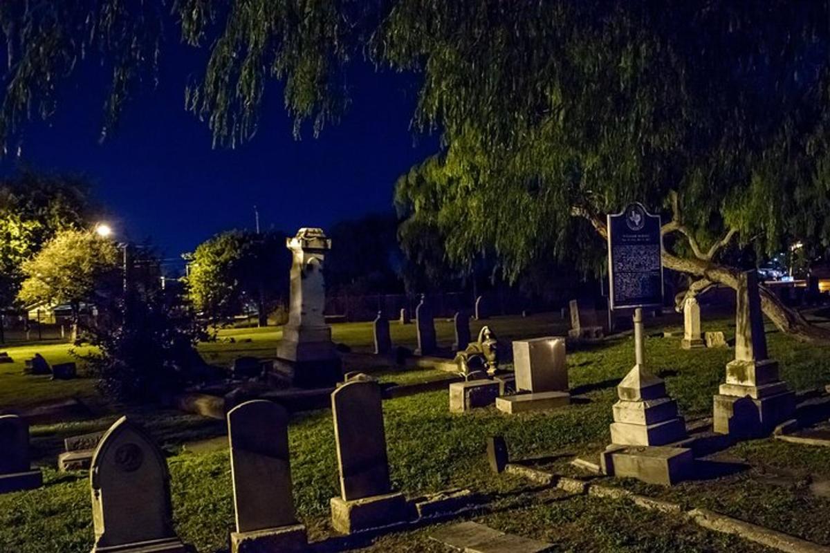 a group of gravestones in a cemetery at night