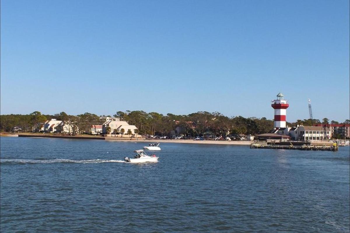 two boats in the water in front of a lighthouse