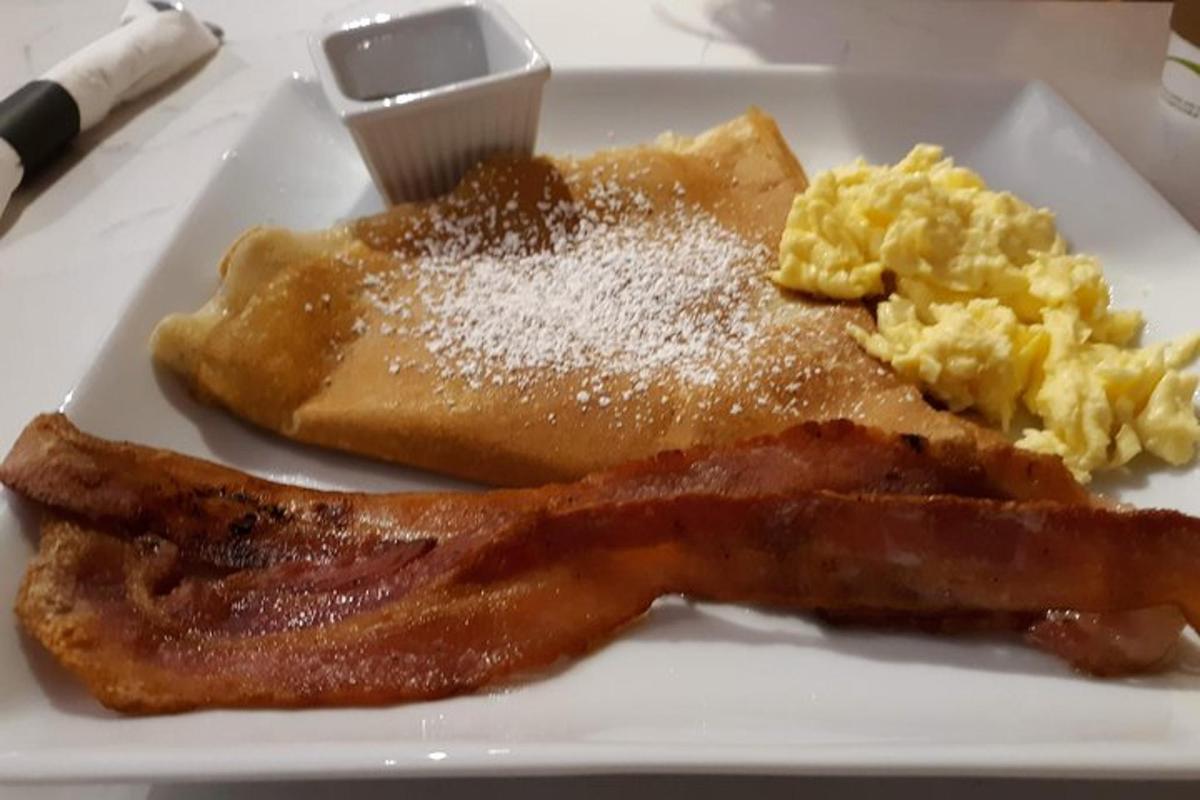 un piatto di cibo per la colazione con pancetta e uova