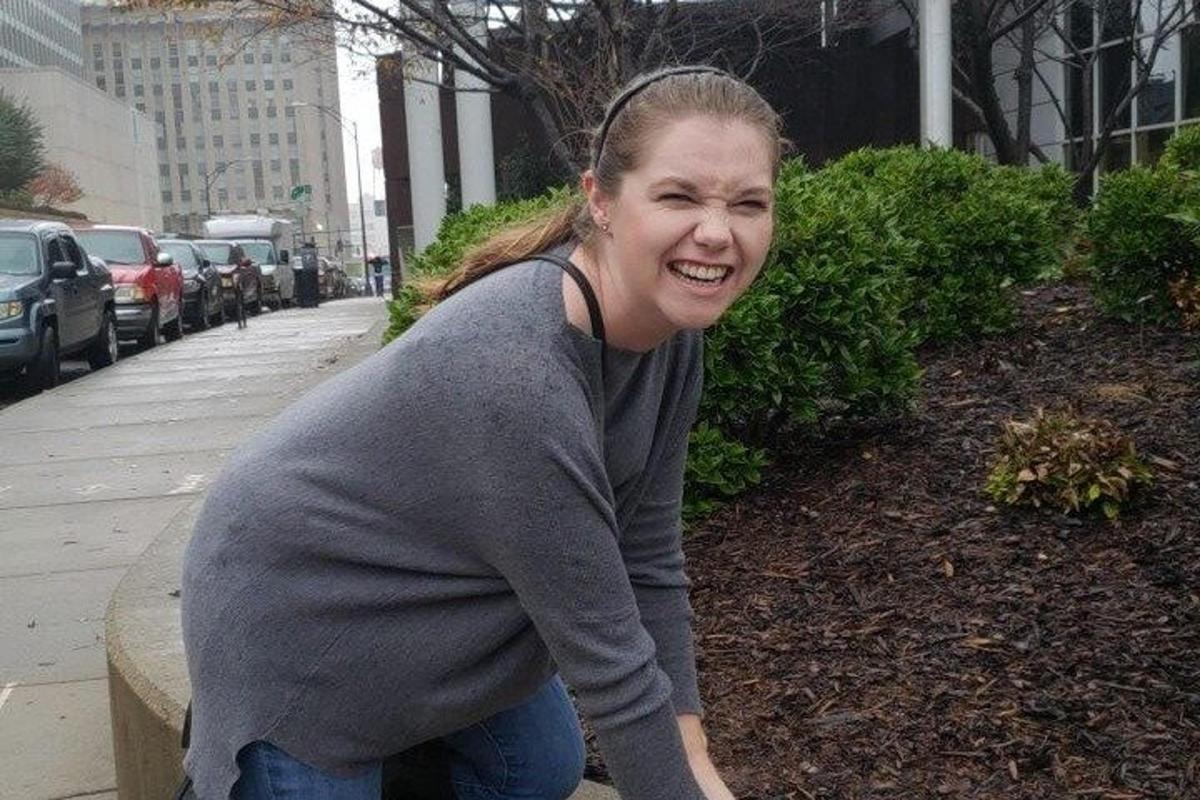 a woman is walking down a sidewalk