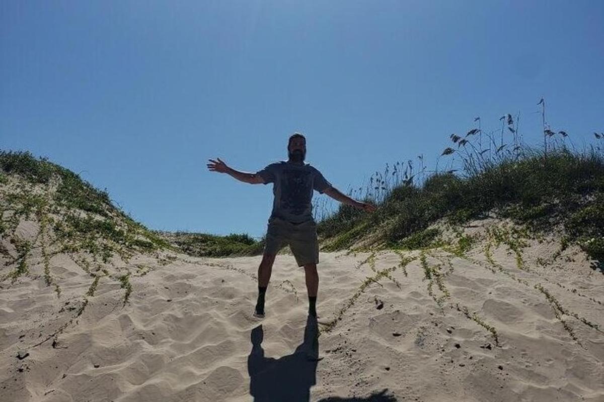 a man standing in the sand on a beach