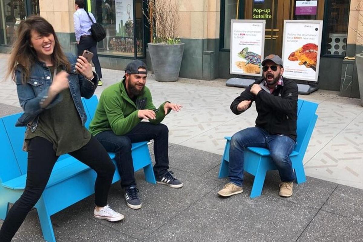 a group of three people sitting on blue benches