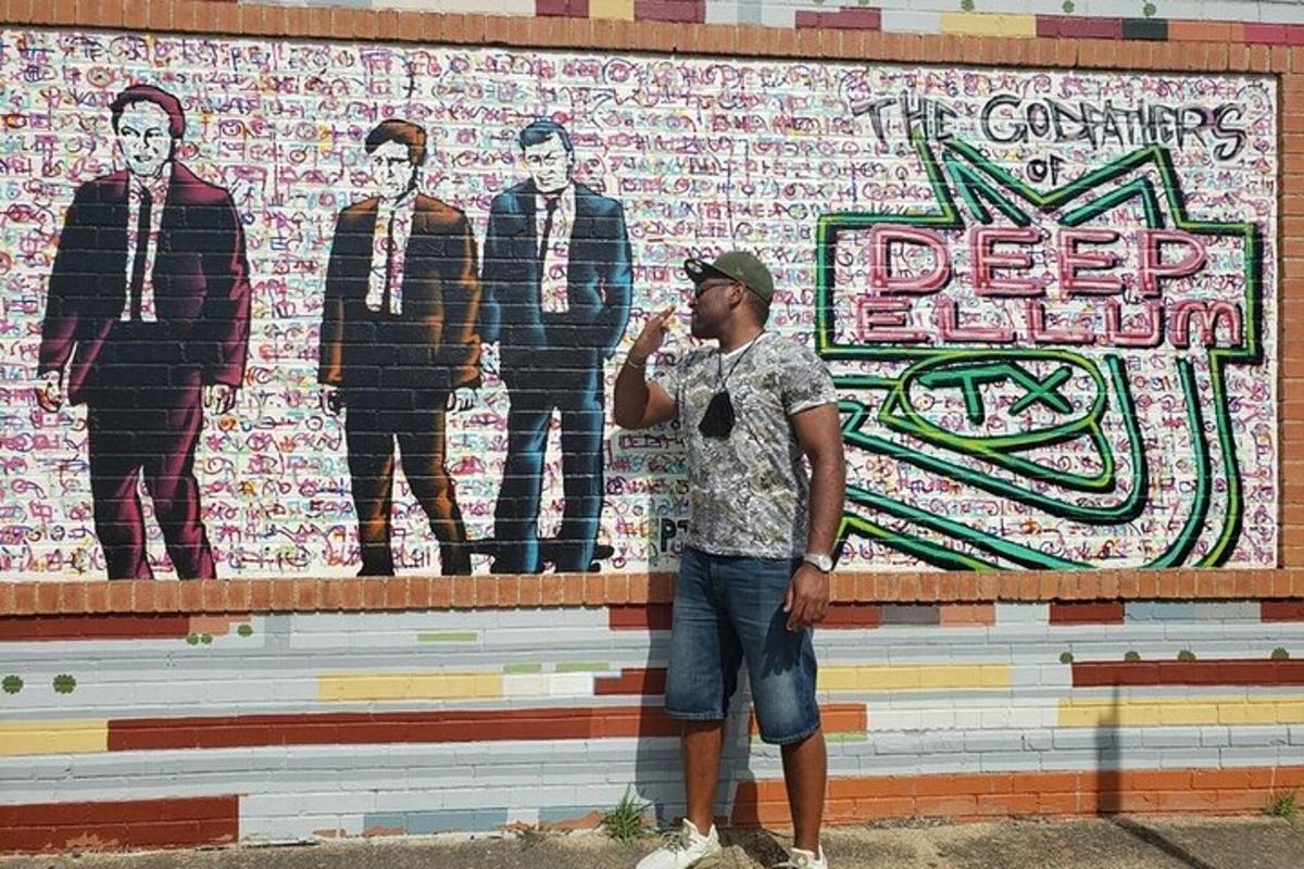 a man standing in front of a wall with a mural