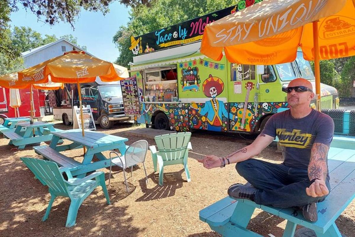a man sitting on a picnic table in front of an ice cream truck