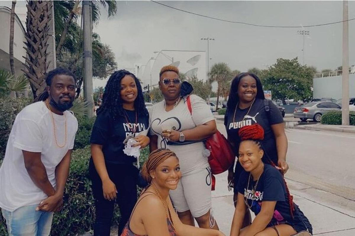 a group of people posing for a picture on the sidewalk
