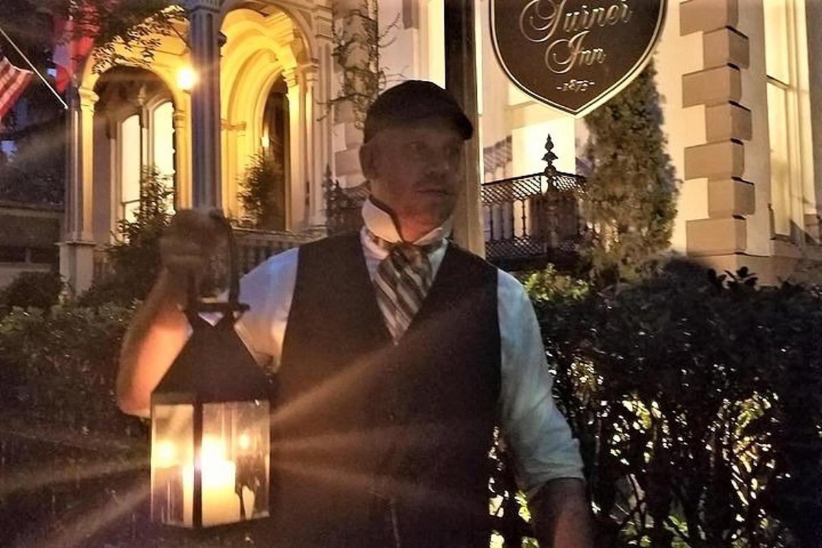 a man holding a light in front of a building