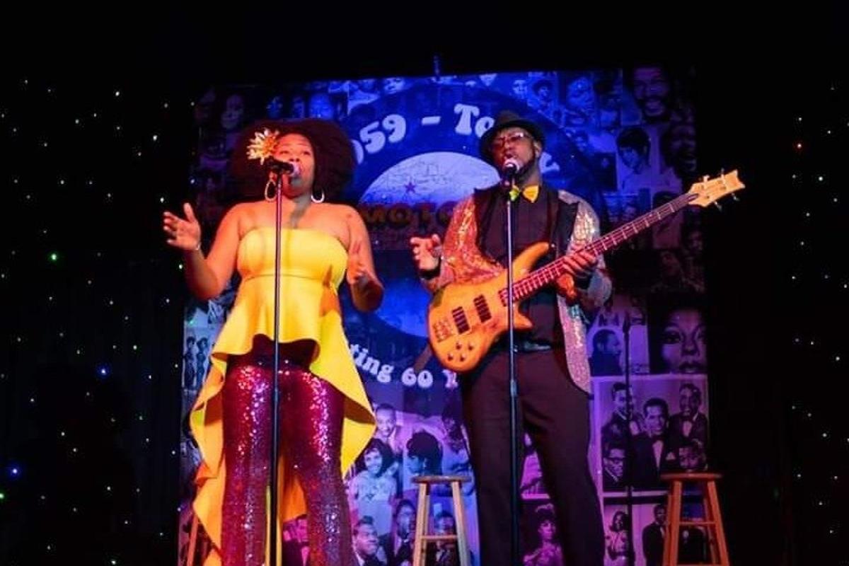 a man and a woman on a stage with a guitar