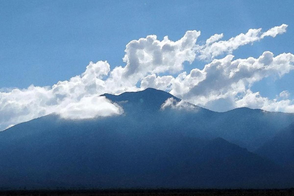 a view of a mountain with clouds in the sky
