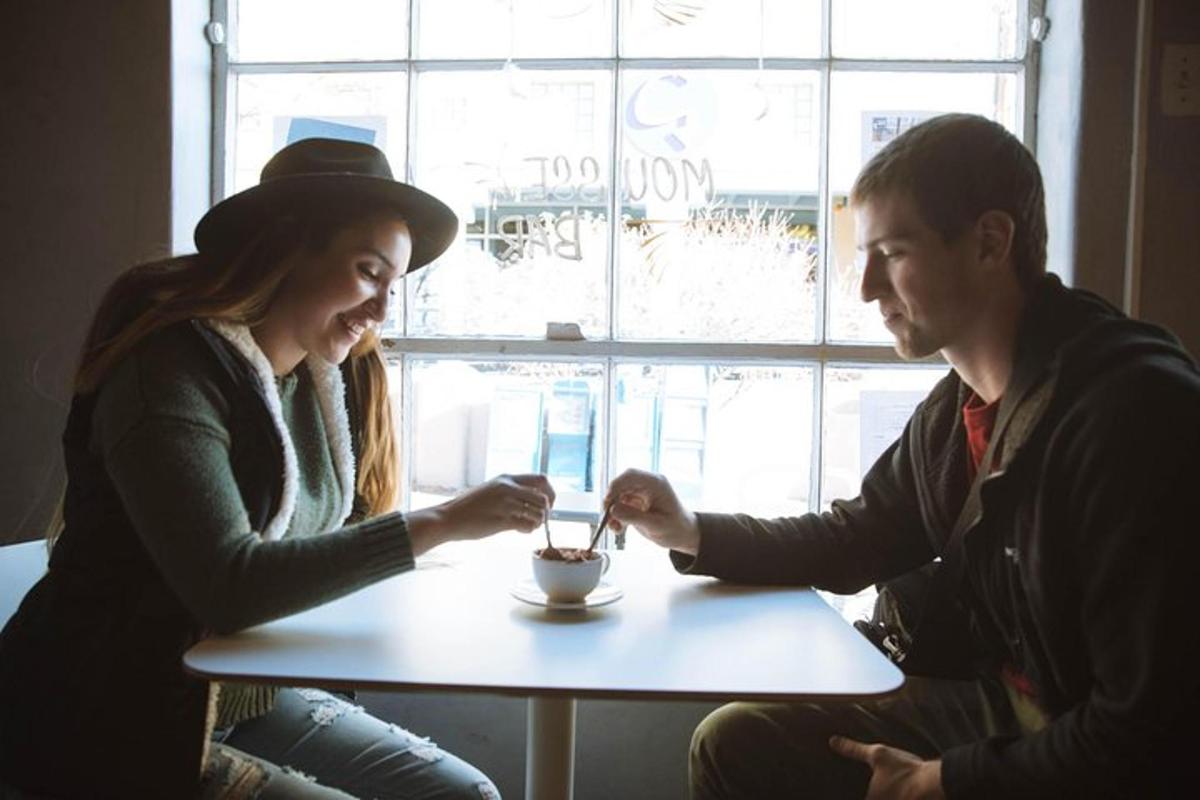 a man and a woman sitting at a table eating food