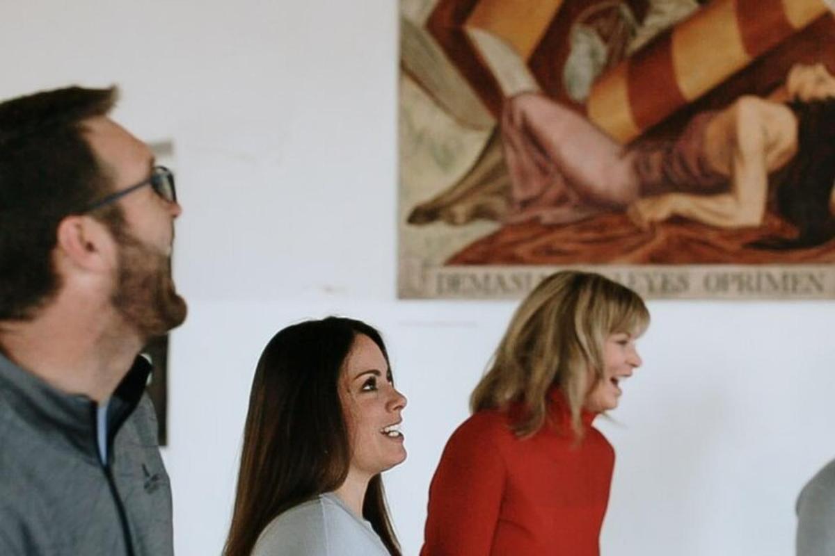 a group of people standing in front of a painting