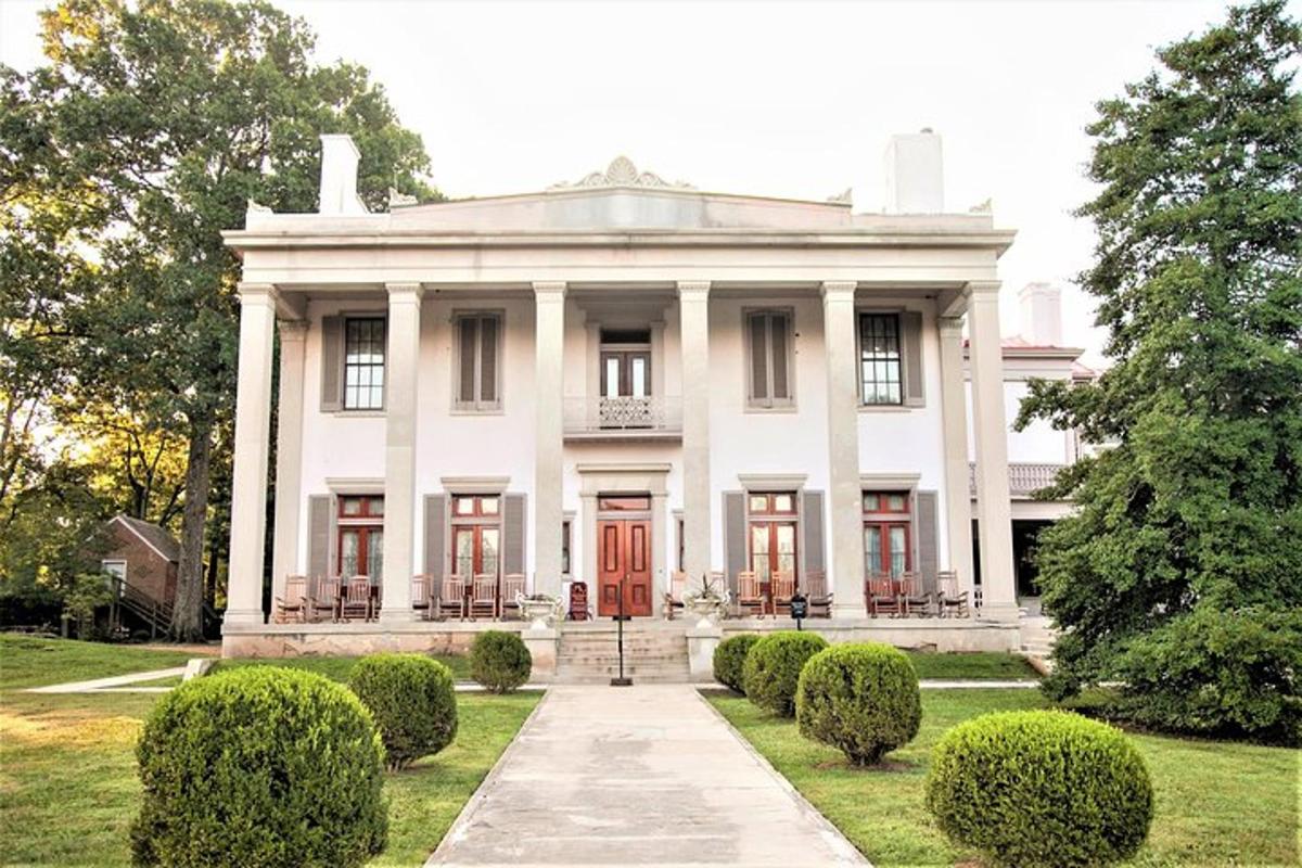 a white house with a red door and some bushes