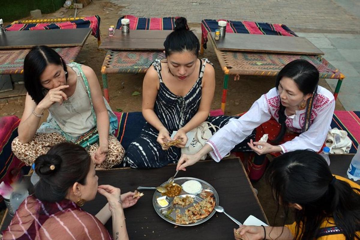a group of women sitting around a table eating food