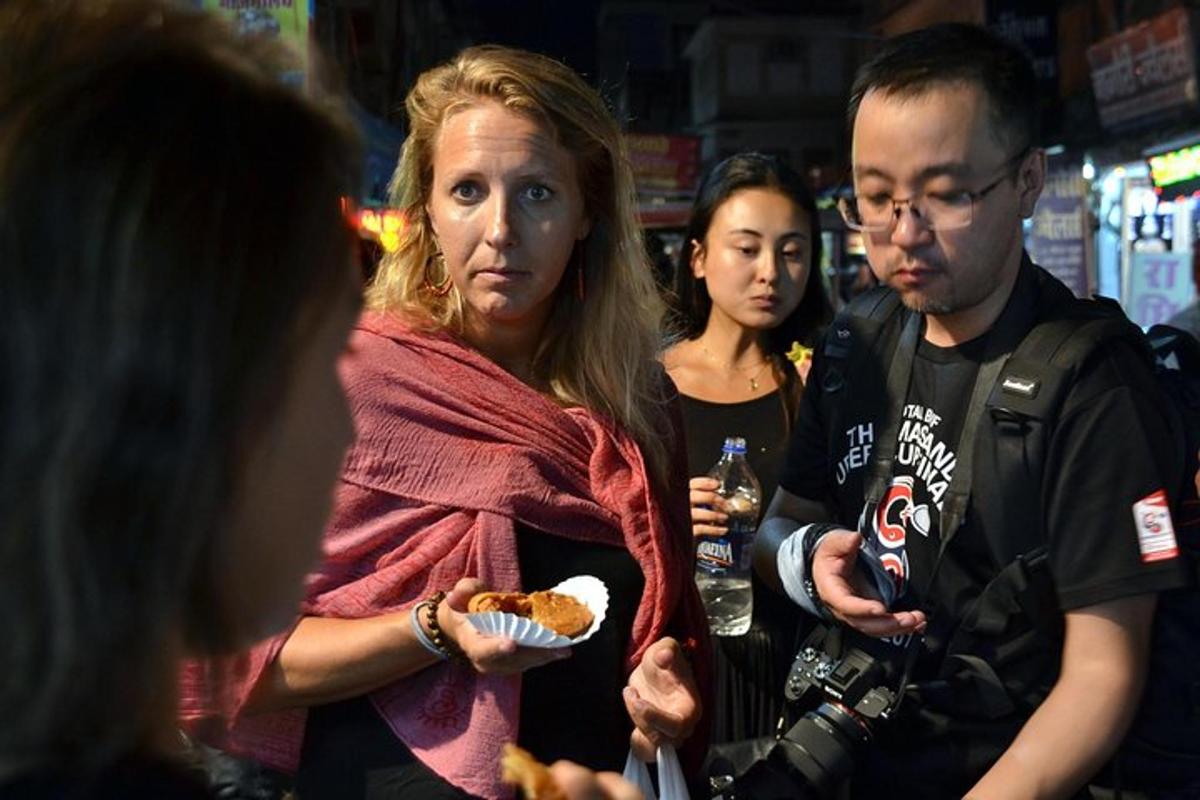 a woman holding a hot dog and a man with a camera