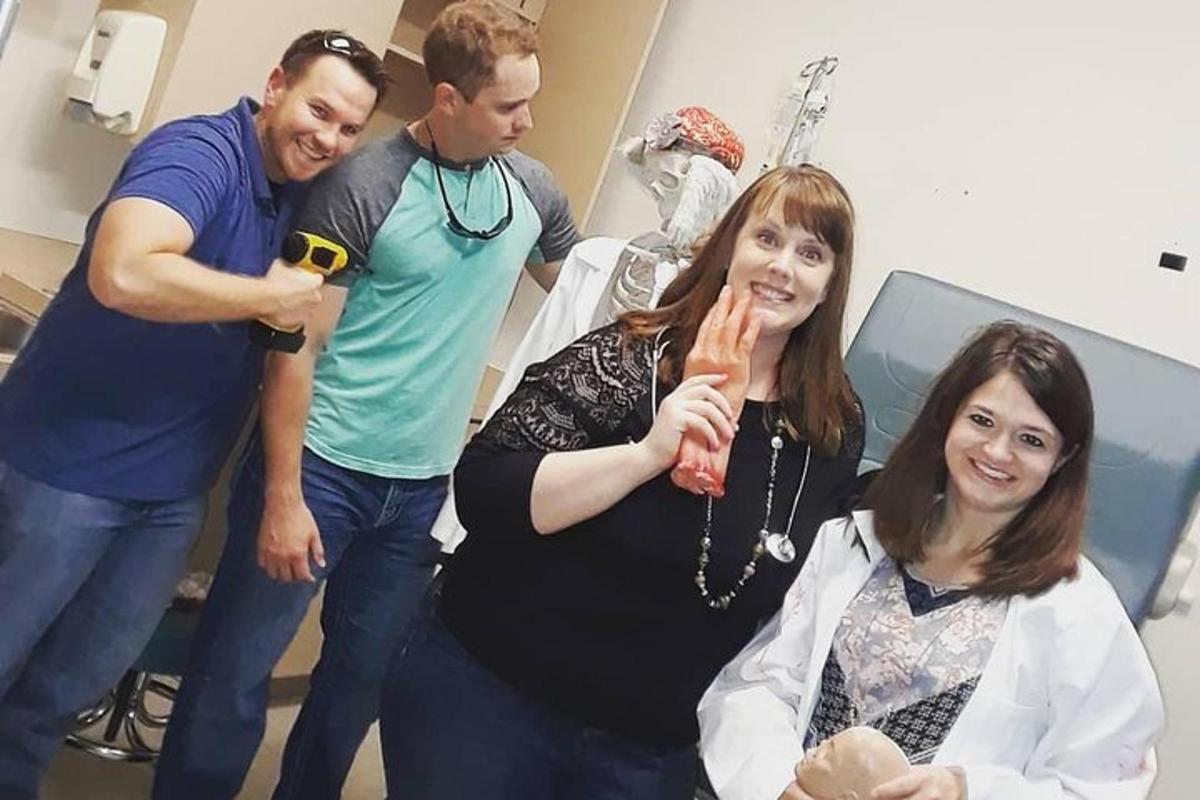 a group of people standing in a hospital room