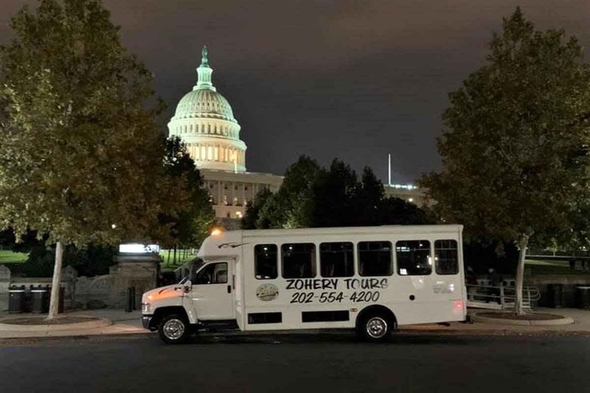 a white bus parked in front of the capitol building