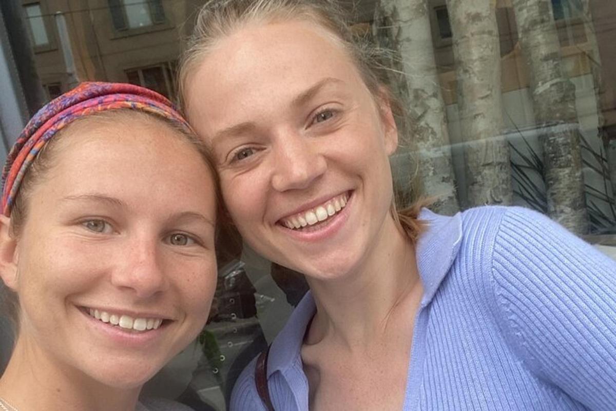 divas sievietes stāv viena otrai blakus