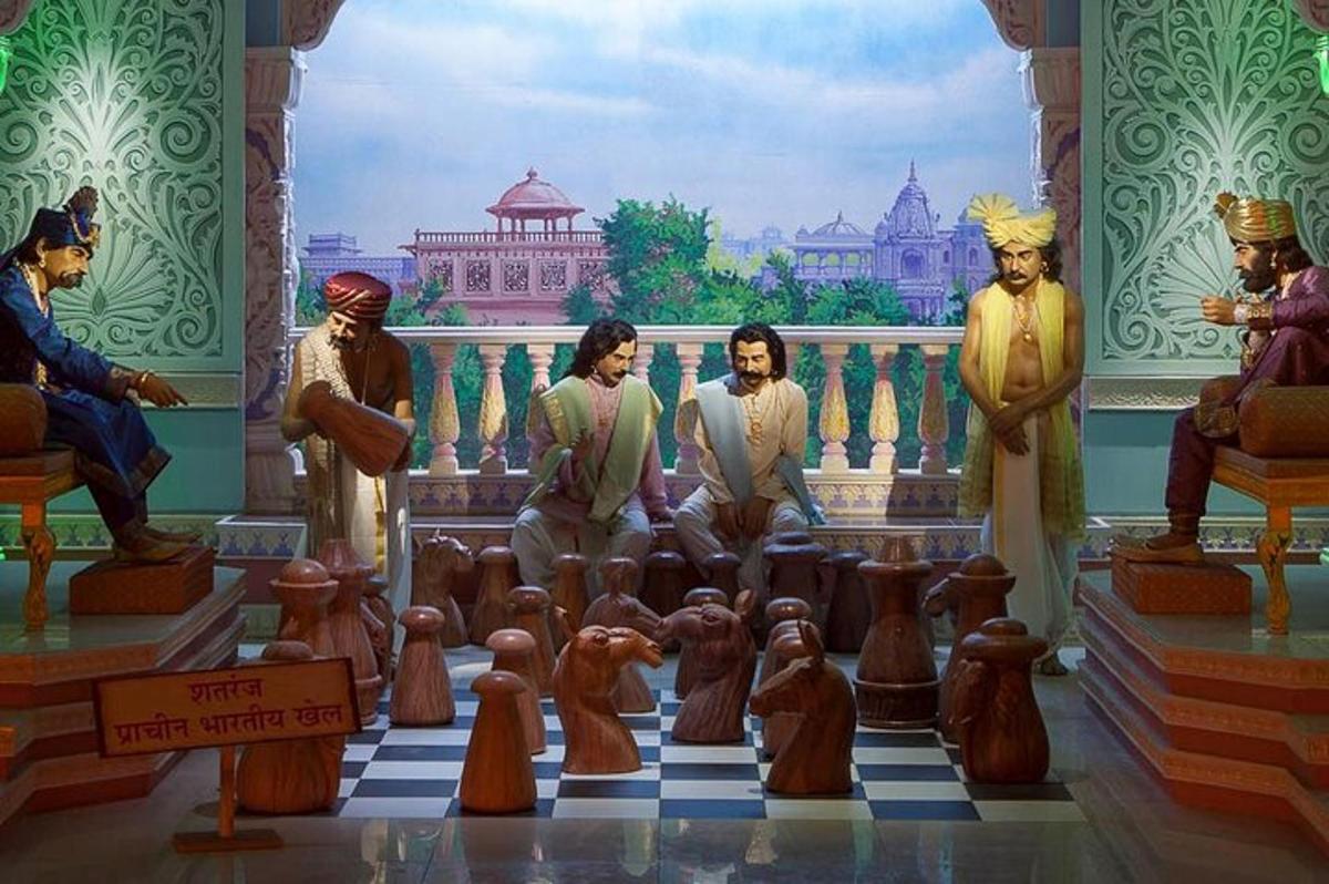 skupina soch mužů na šachovnici