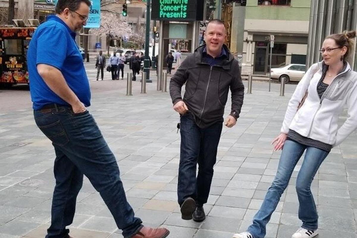 doi bărbați și o femeie mergând pe stradă