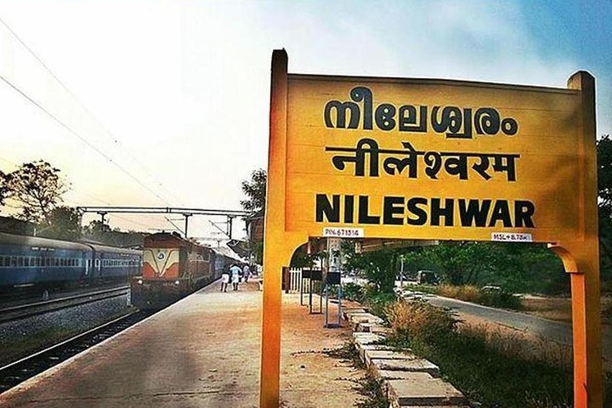 a sign at a train station with a train