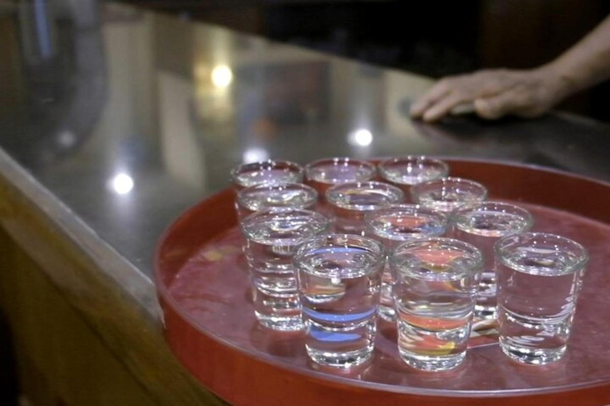 tác naplněný sklenicemi vody na pultu