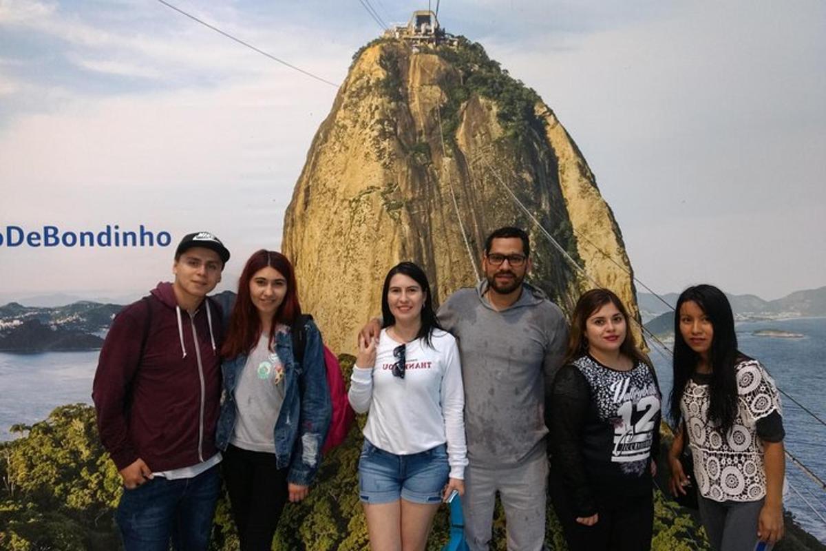 a group of people standing in front of a rock