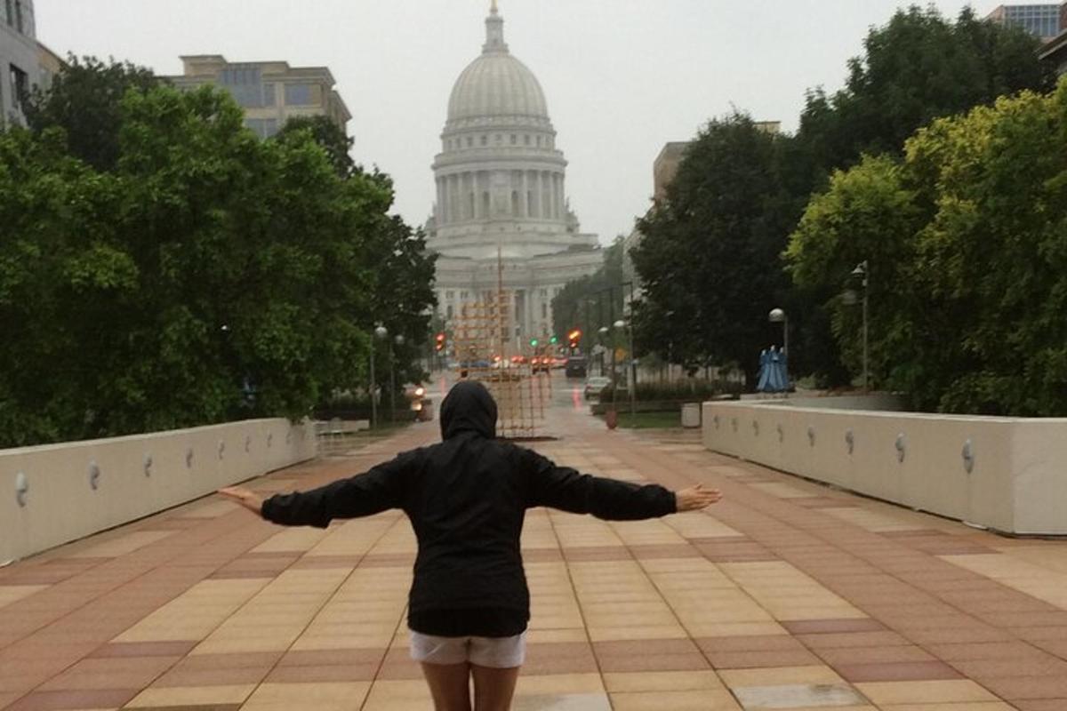 a person walking down a street with their arms outstretched