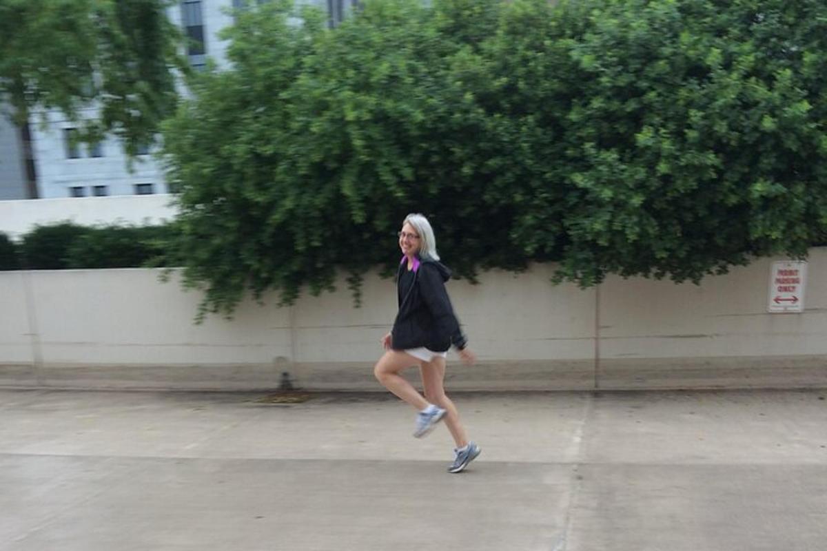 a woman in a suit and tie walking on a sidewalk