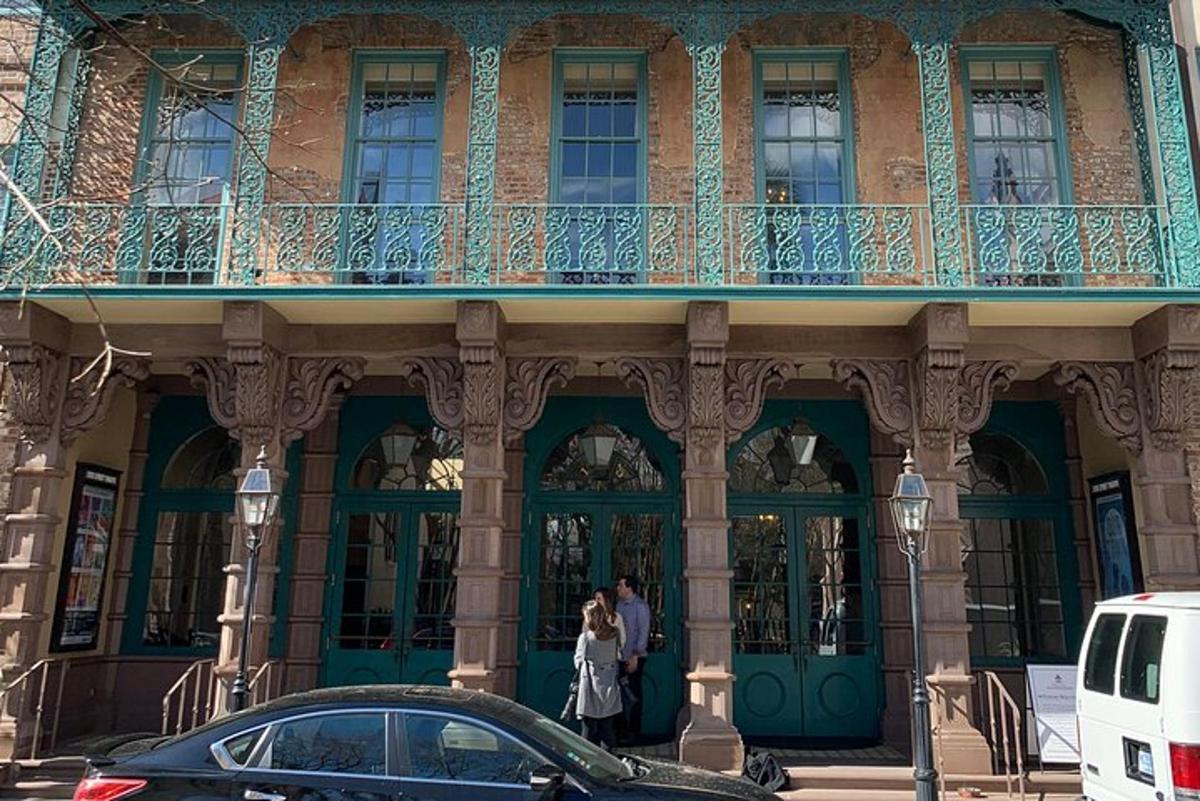 two people standing outside of a building with a balcony