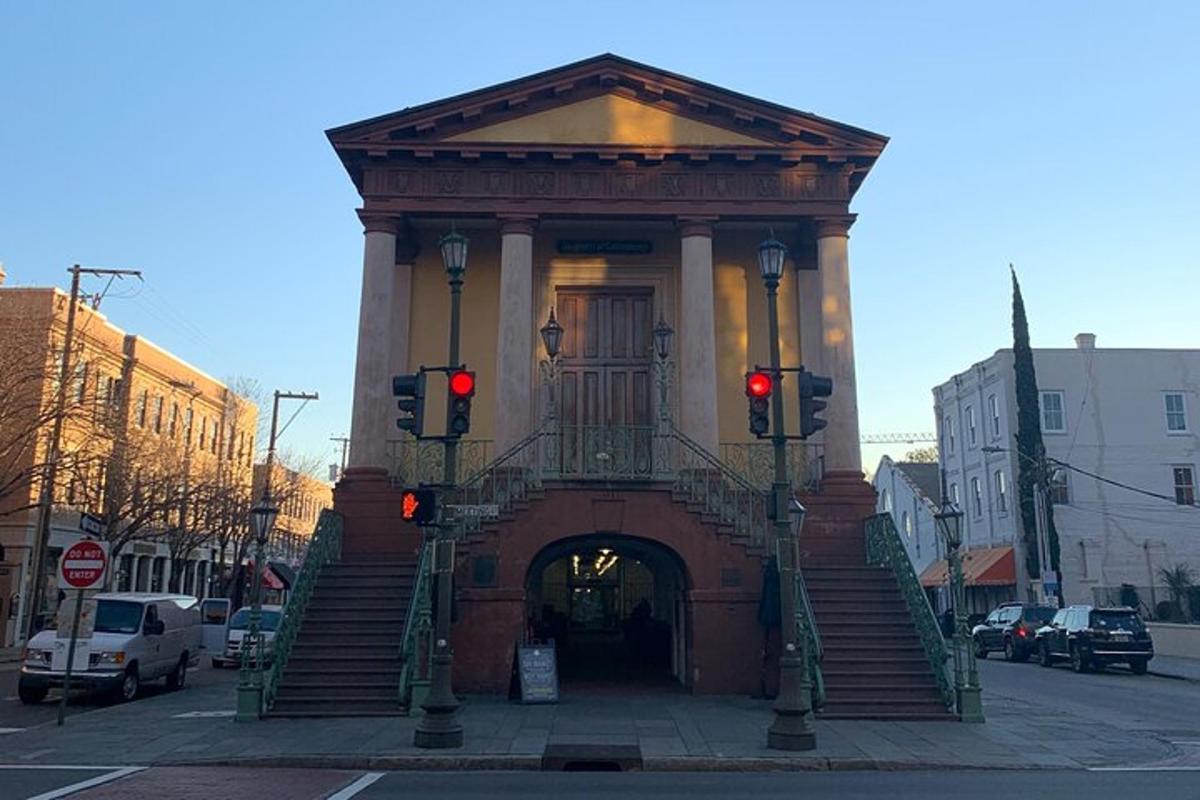 a large building with a gate and stairs in a street