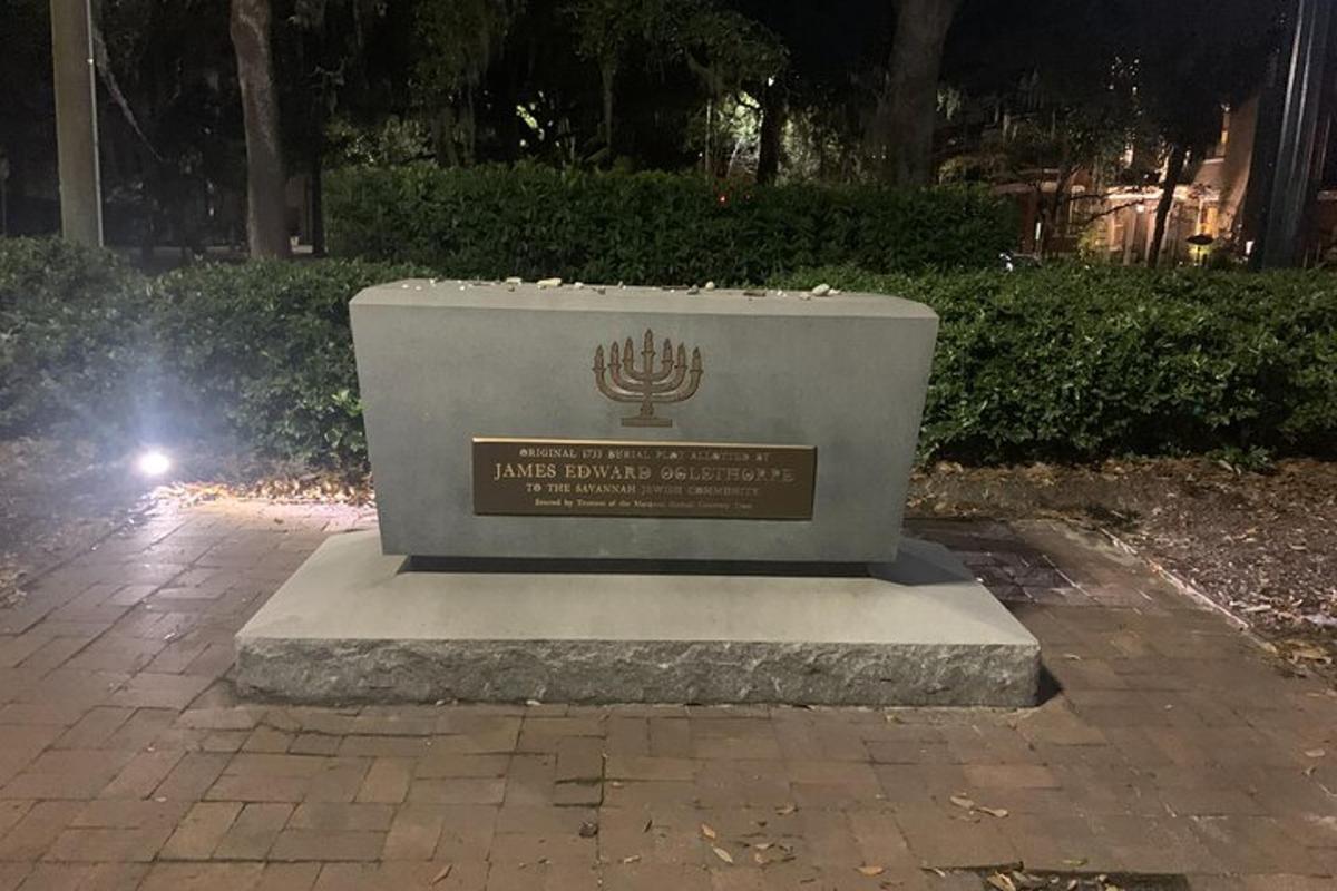a statue of a menorah in a park at night