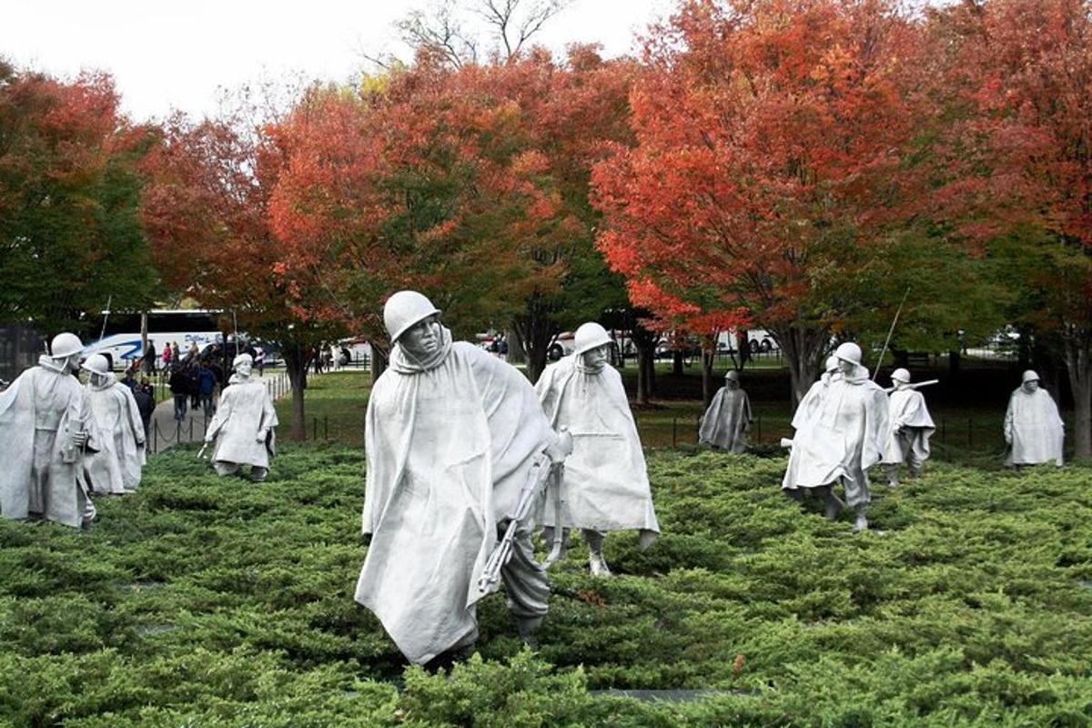um grupo de pessoas vestidas de branco caminhando em um campo