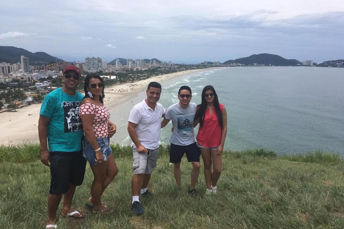 un grup de persones dretes en un turó al costat de la platja