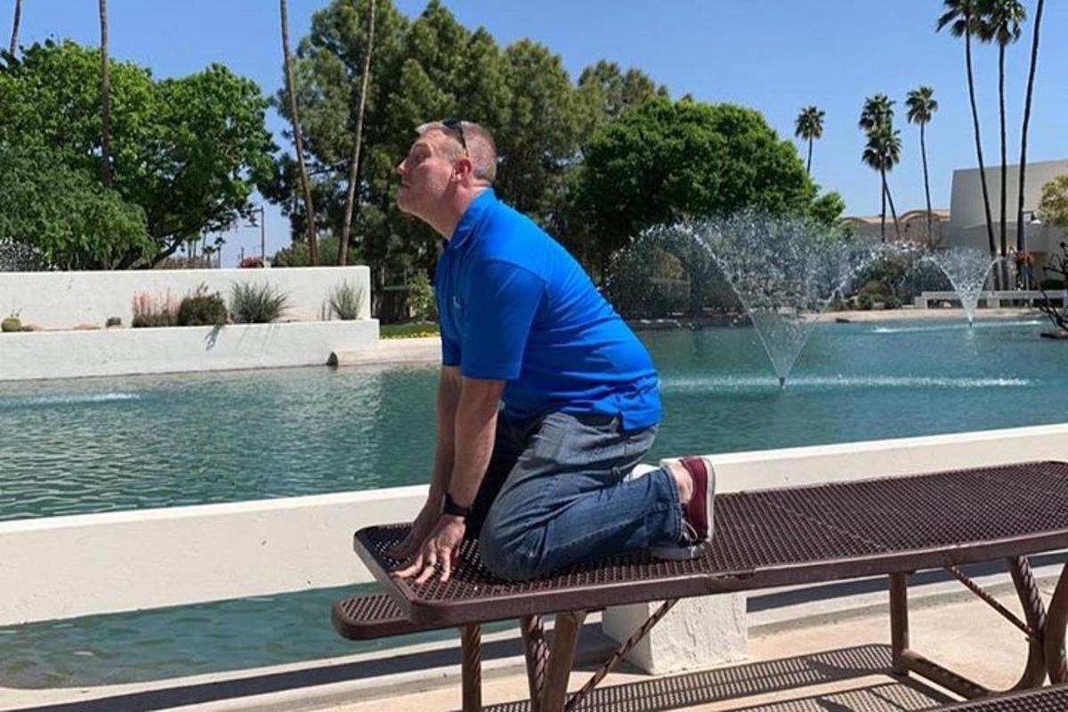 a man sitting on a bench in front of a fountain