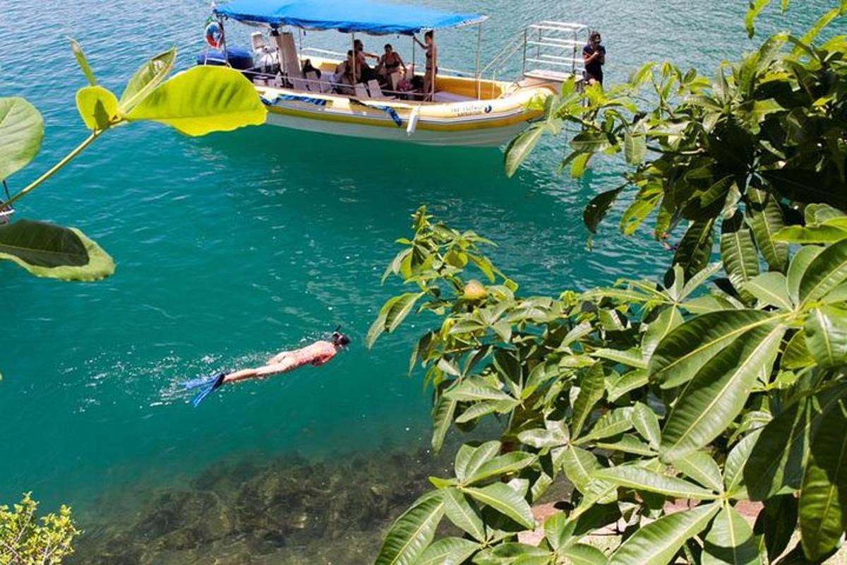 a man swimming in the water next to a boat