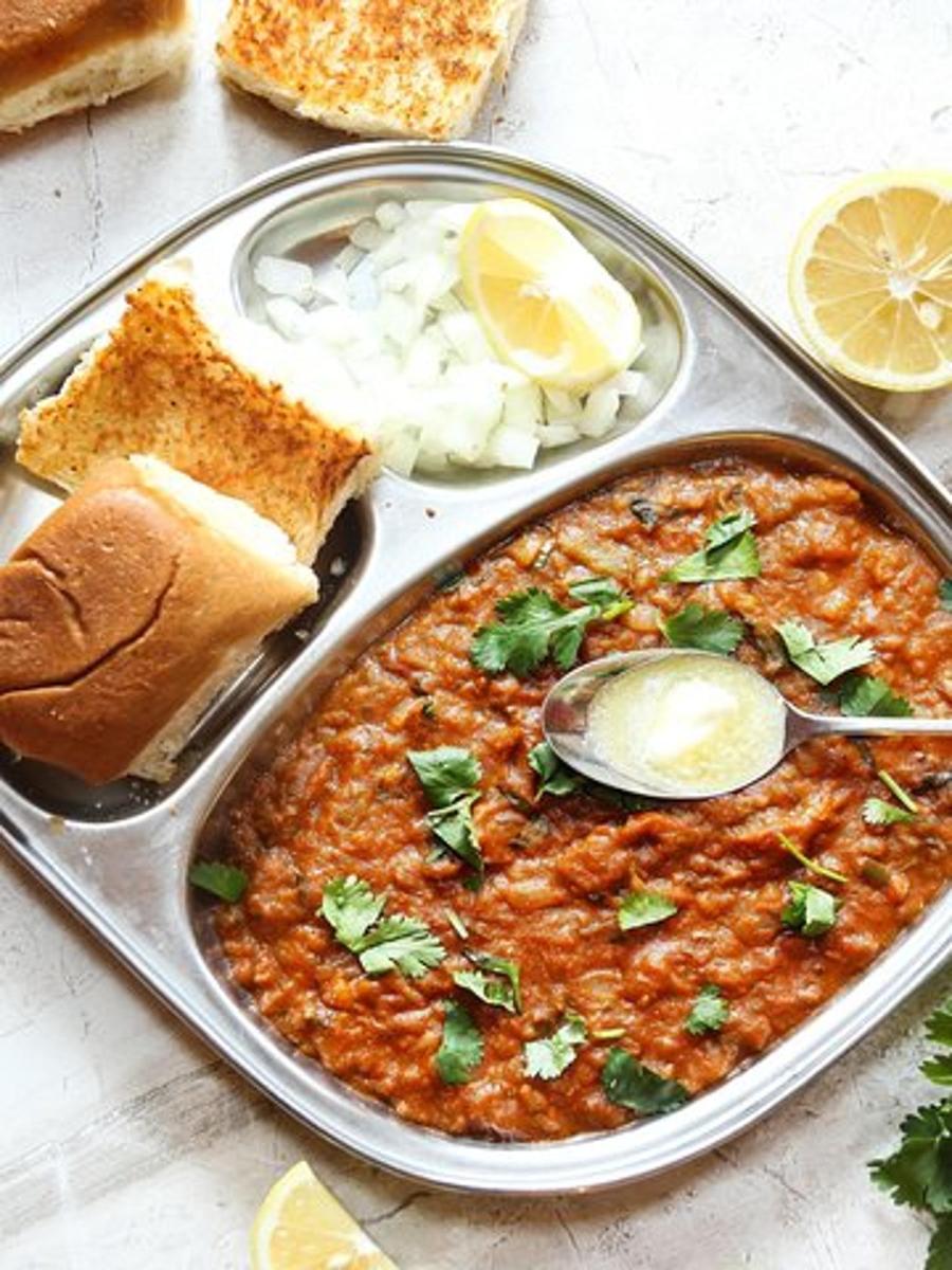 a tray of food with a dish of chili and bread